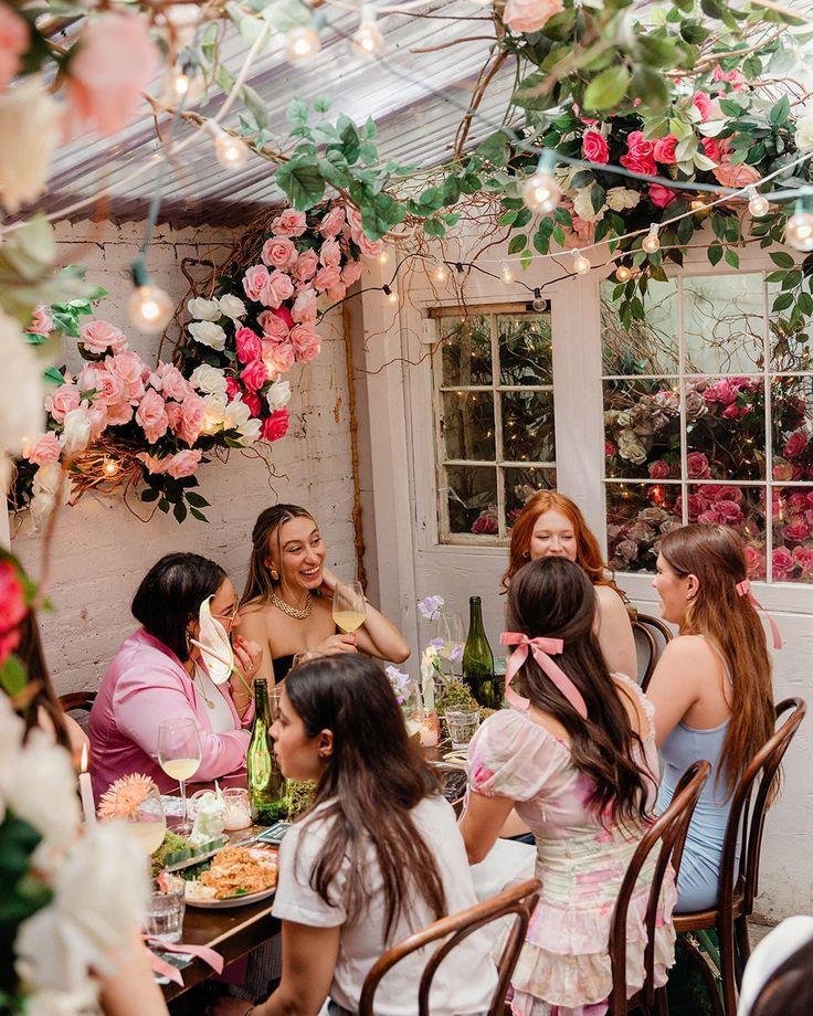 A group of girls at an event sitting at a table and sharing stories.