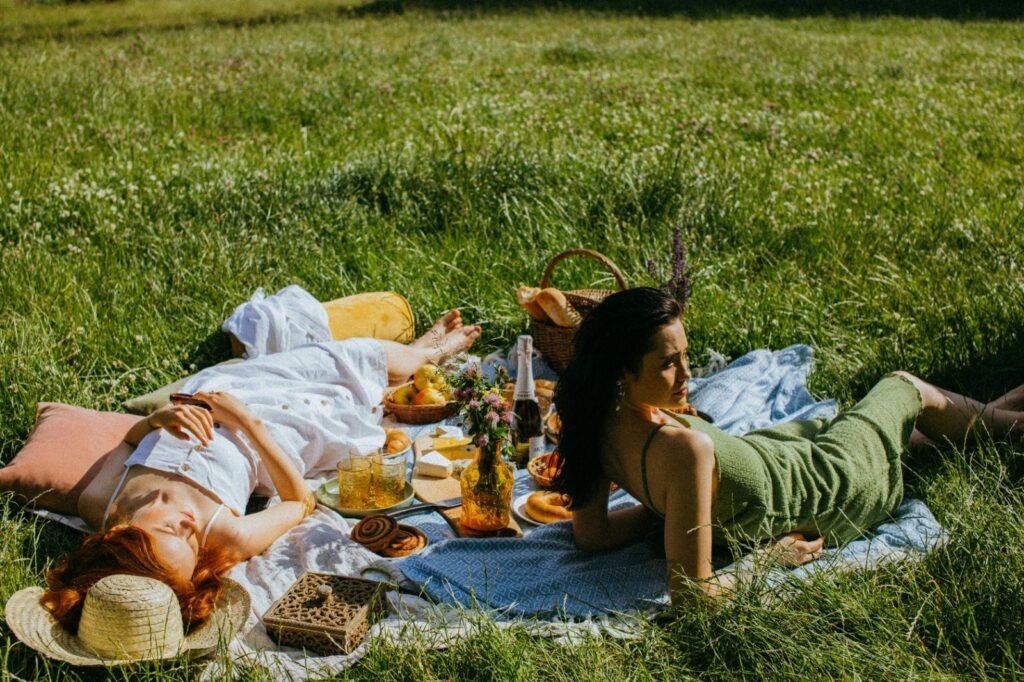 Girls sitting in the grass, at a picnic, relaxing